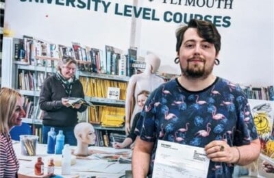 A Petroc student holding up his grades