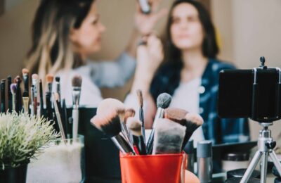 A close up on some makeup brushes with students in the background