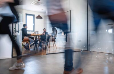 Businesspeople in Conference Room and Colleagues Walking By