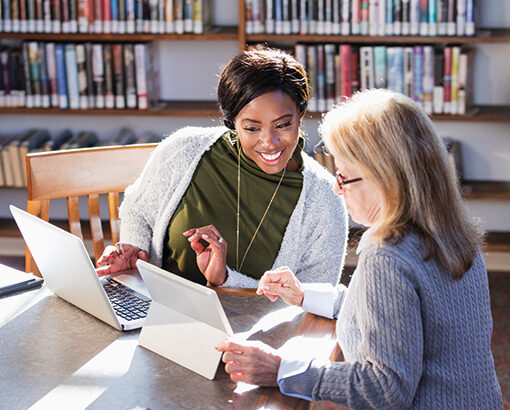 two adult learners working on laptops