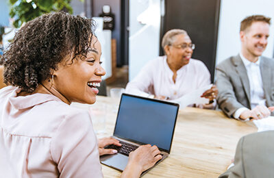 woman typing on a laptop at a meeting