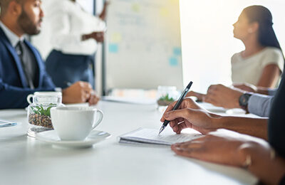 Person taking notes while sitting in a meeting