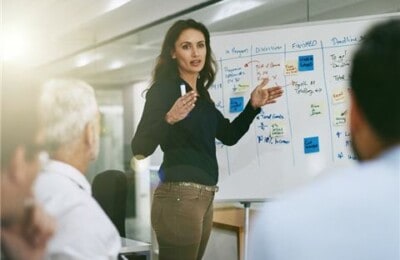 A lady presenting to a group of colleagues