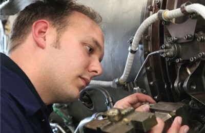 An apprentice working on some machinery