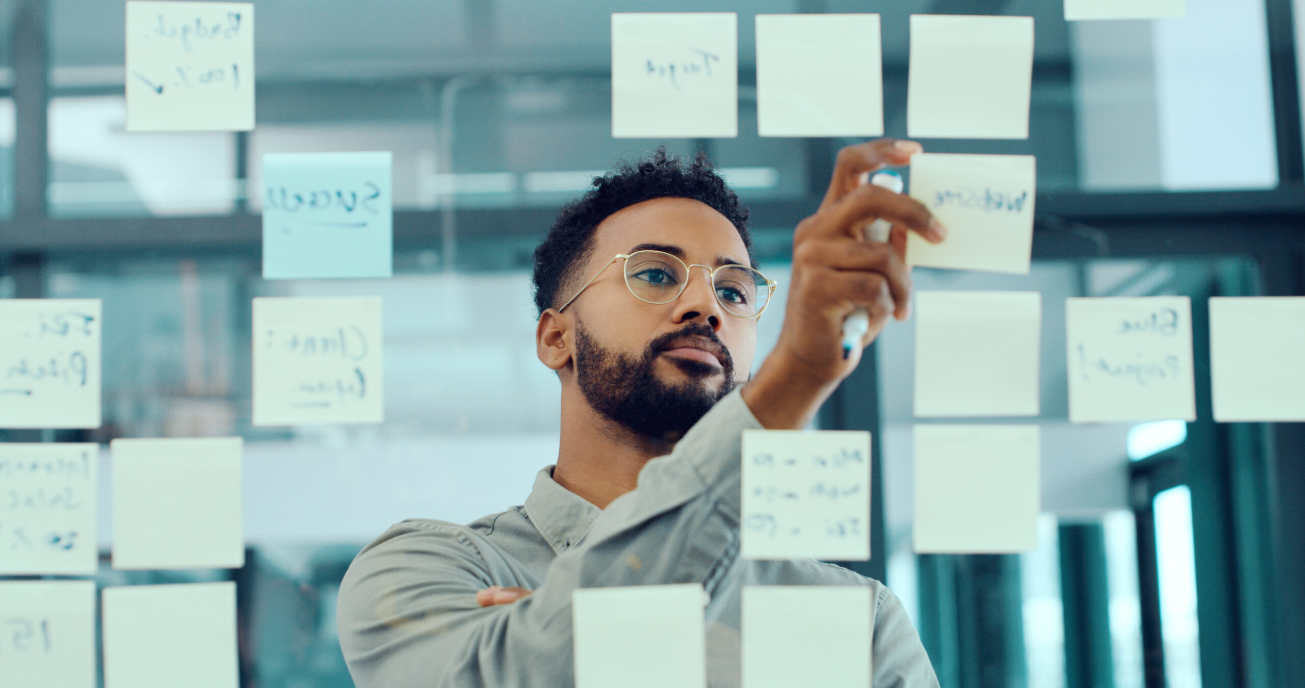 Man Putting Post Stick Notes On Window