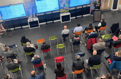 Participants at event sitting and listening to a talk