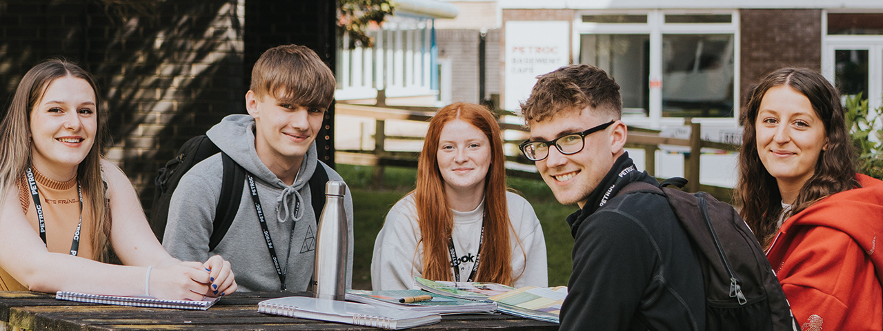 students sitting in group around an outside table