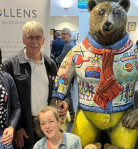 A group of guests stood with a model bear from the CHSW bear hunt exhibition