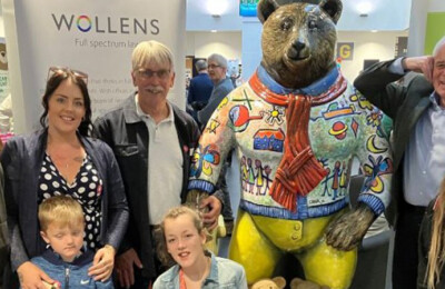 A group of guests stood with a model bear from the CHSW bear hunt exhibition