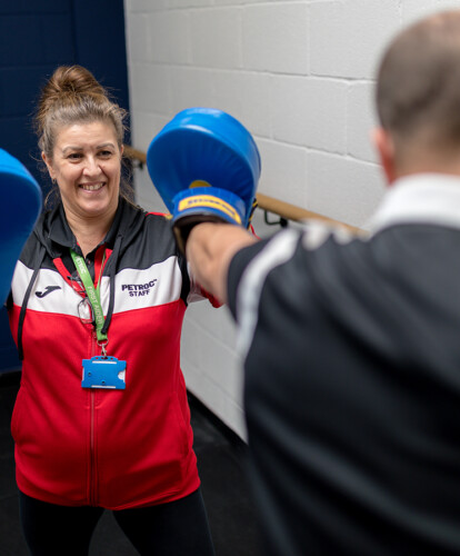An image of a fitness instructor sparring with a student