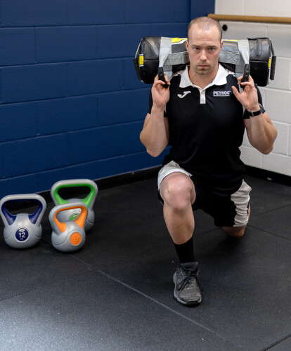 An image of a gym member using some weights