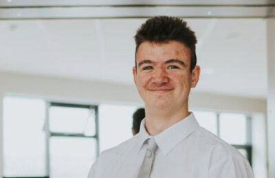 Student standing in bar area of restaurant.