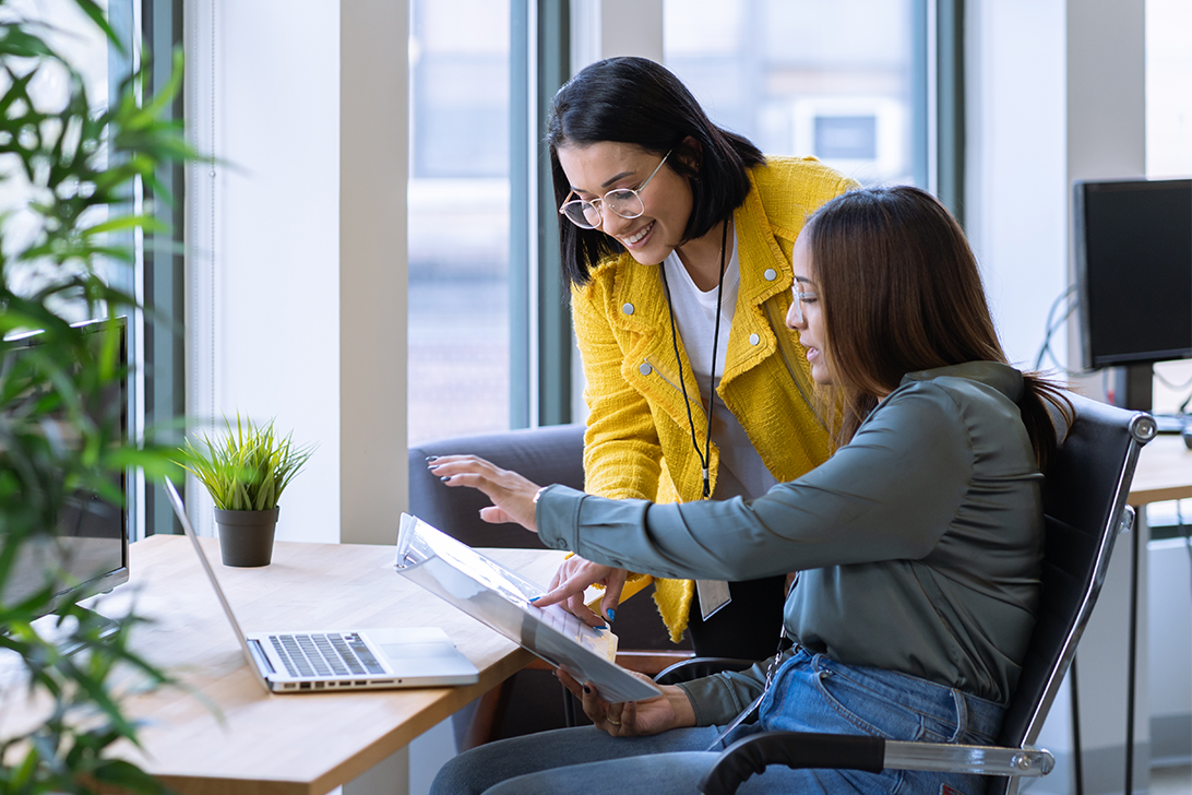 two women looking at a laptop together