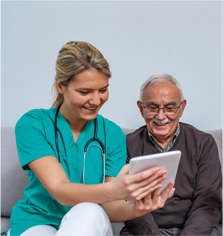 feamle carer looking at an ipad with an elderly gentleman
