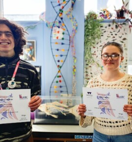 Two students holding certificates