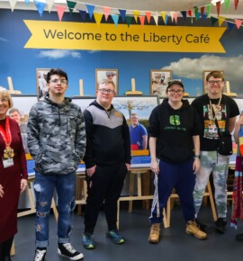 Supported Internship students stood infront of their posters