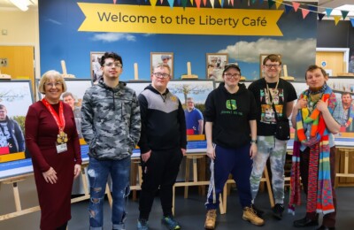 Supported Internship students stood infront of their posters